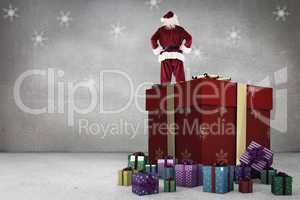 Composite image of santa standing on giant present