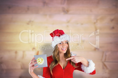 Composite image of sexy santa girl holding gift