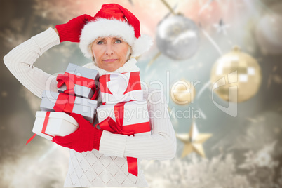 Composite image of festive woman holding gifts