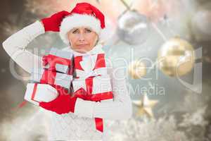 Composite image of festive woman holding gifts