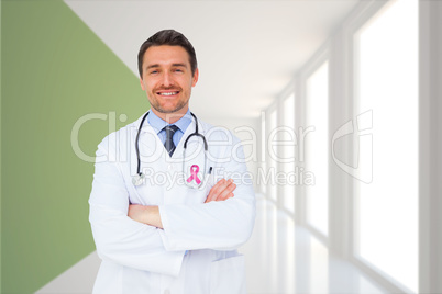 Composite image of handsome young doctor with arms crossed