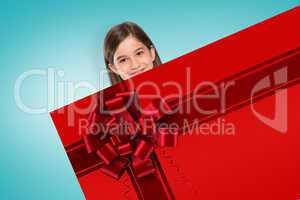 Cute girl showing card with christmas ribbon