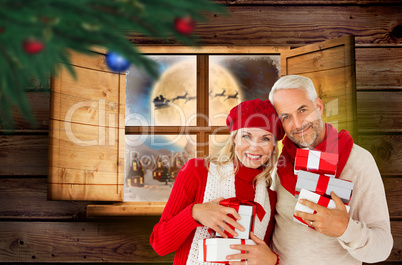 Composite image of happy festive couple with gifts