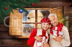 Composite image of happy festive couple with gifts