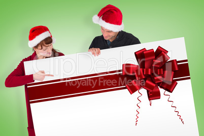 Couple holding a sign with red ribbon