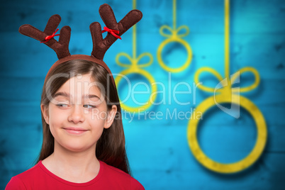 Composite image of festive little girl wearing antlers