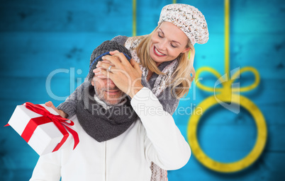 Composite image of happy winter couple with gift