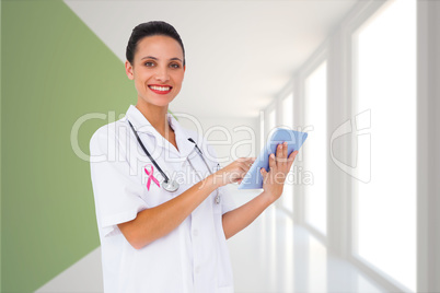 Composite image of pretty nurse using tablet pc