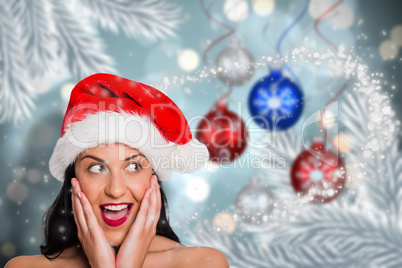 Composite image of surprised woman wearing santa hat