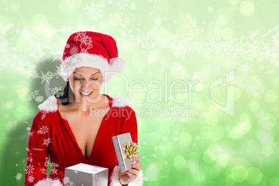 Composite image of smiling woman opening christmas present