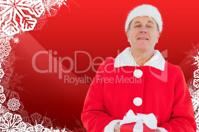 Composite image of festive man holding gift