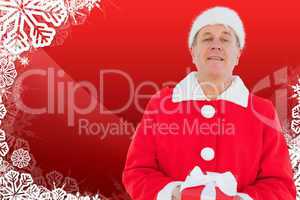 Composite image of festive man holding gift