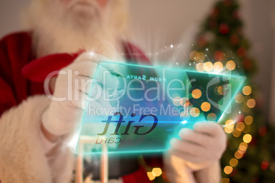 Composite image of santa using futuristic touchscreen