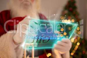 Composite image of santa using futuristic touchscreen