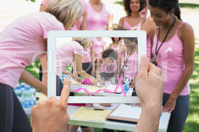 Composite image of hand holding tablet pc