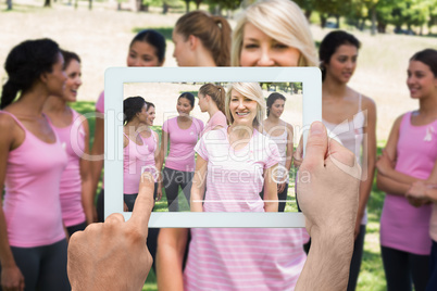 Composite image of hand holding tablet pc