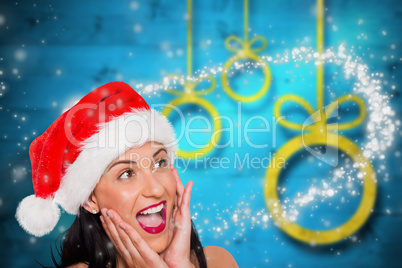 Composite image of surprised woman wearing santa hat