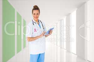 Composite image of pretty nurse using tablet pc