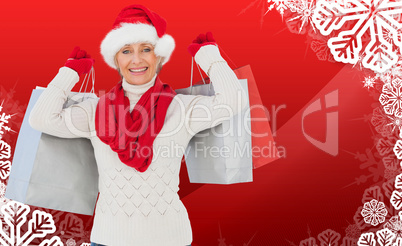 Composite image of festive woman holding shopping bags