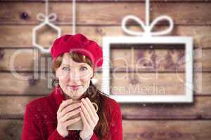 Composite image of woman holding a warm cup