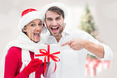 Composite image of festive young couple holding gift