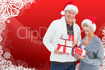 Composite image of festive mature couple holding christmas gifts Composite image of festive mature couple holding christmas gifts