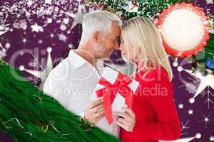 Composite image of loving couple with gift