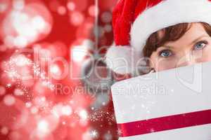 Composite image of woman holding a christmas present