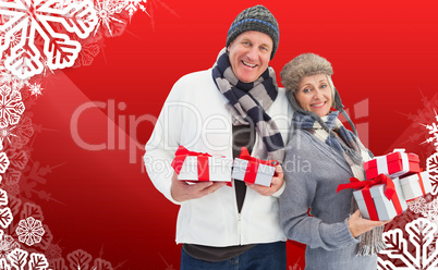 Composite image of festive mature couple holding christmas gifts