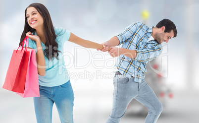 Composite image of happy couple with shopping bag