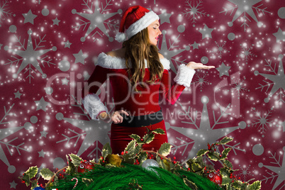 Composite image of pretty girl in santa costume holding hand out