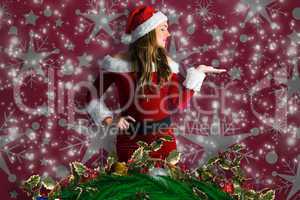 Composite image of pretty girl in santa costume holding hand out