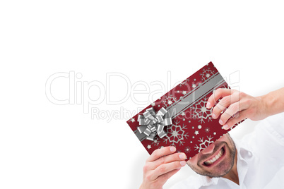 Composite image of festive man holding christmas gift