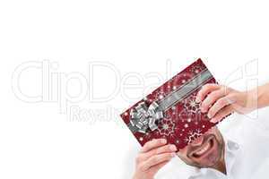 Composite image of festive man holding christmas gift