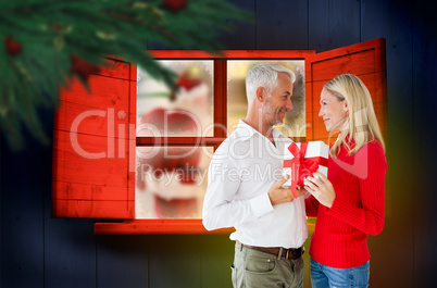 Composite image of loving couple with gift