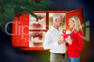 Composite image of loving couple with gift