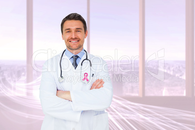 Composite image of handsome young doctor with arms crossed