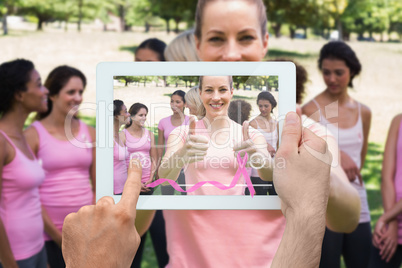 Composite image of hand holding tablet pc