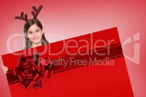 Composite image of festive little girl showing card