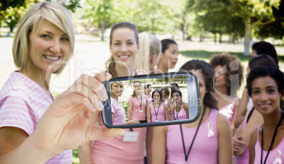 Composite image of hand holding smartphone showing