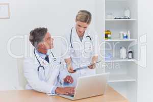 Composite image of nurse showing a folder to her colleague