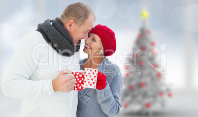 Composite image of mature couple holding mugs