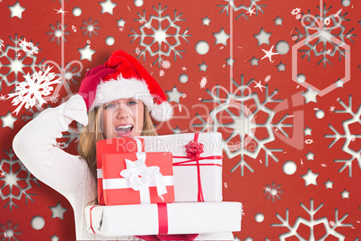 Composite image of festive blonde holding pile of gifts