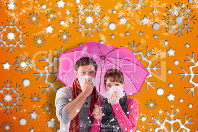 Composite image of couple standing underneath an umbrella