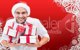 Composite image of festive man holding christmas gifts