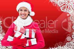 Composite image of festive brunette holding gifts