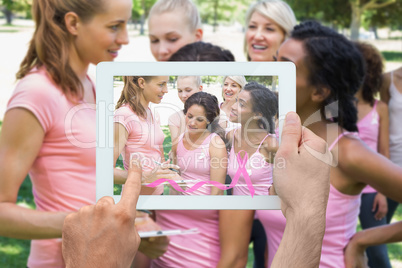 Composite image of hand holding tablet pc