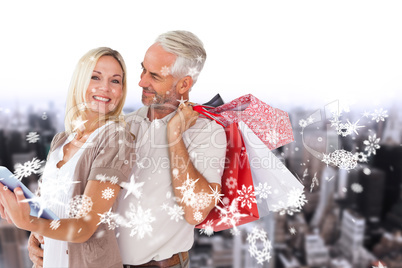 Composite image of happy couple with shopping bags and tablet pc