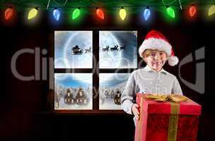 Composite image of festive boy holding gift