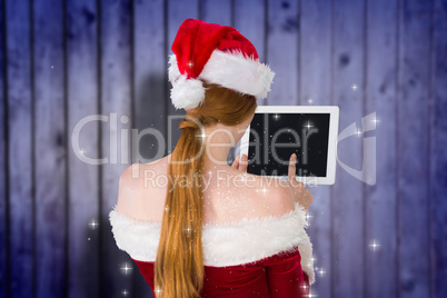 Composite image of pretty santa girl using tablet pc